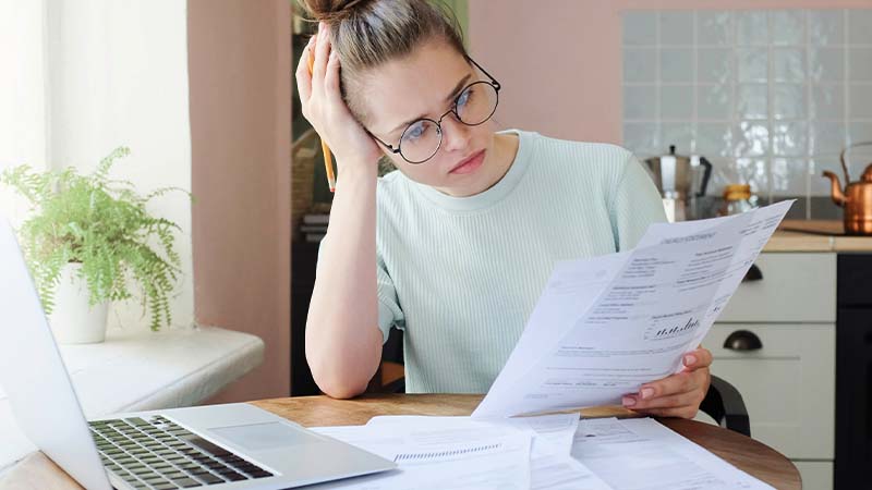 Mulher à mesa com laptop a analisar faturas de energia